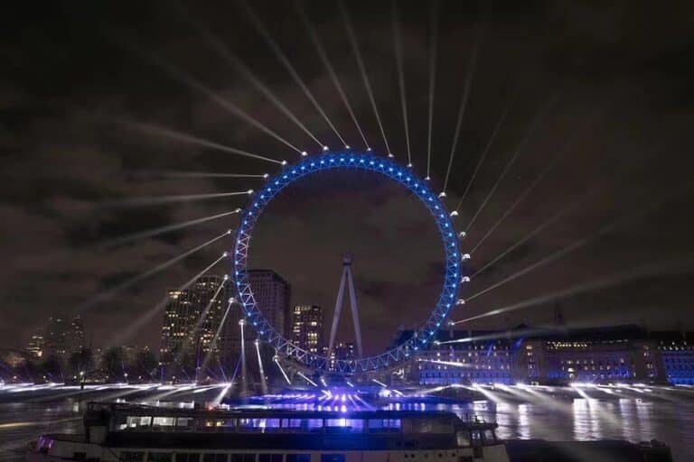 Rueda de la fortuna y paseo marítimo iluminados con luz arquitectónica azul